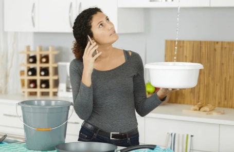 Vrouw belt aannemer terwijl plafond lekt