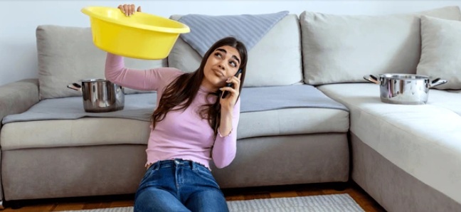 Vrouw vangt lekkage op terwijl ze belt