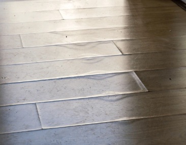 Opgebolde houten vloerplanken door lekkage